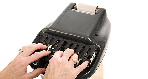 Closeup of a court reporters hands typing on a stenograph machine. Isolated on white background.