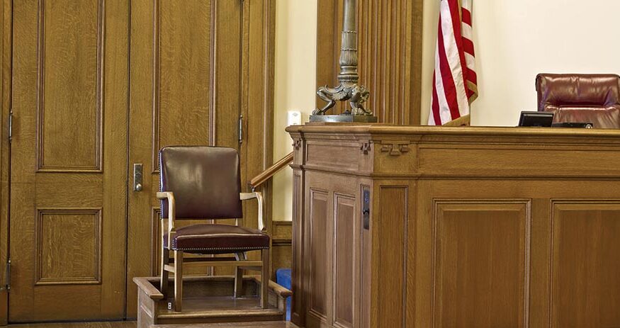 A courtroom witness stand chair in a generic courthouse