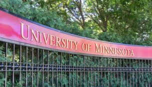A view of a gate and sign at the entrance to the University of Minnesota