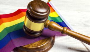 Judge gavel on rainbow LGBT flag on wooden table