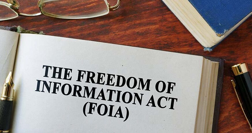 An open book with the words "THE FREEDOM OF INFORMATION ACT (FOIA)" printed on it