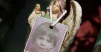 A photograph of Etan Patz hangs on an angel figurine