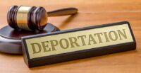 A gavel and a name plate with the engraving Deportation