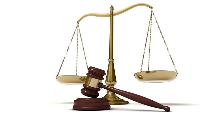 Scales of justice and a gavel in front of a white background