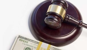 A Gavel,wood,block and pile of money isolated against white background