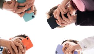 Low angle view of teenager group using phones. Digital addiction and concept.