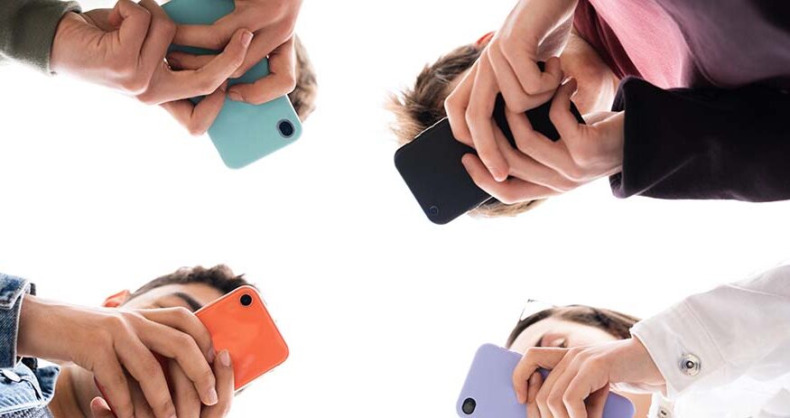 Low angle view of teenager group using phones. Digital addiction and concept.
