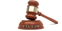 A gavel atop a block with words reading "TAX LAW"