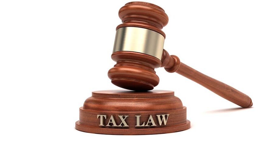 A gavel atop a block with words reading "TAX LAW"