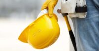 builder with yellow helmet and working gloves on building site