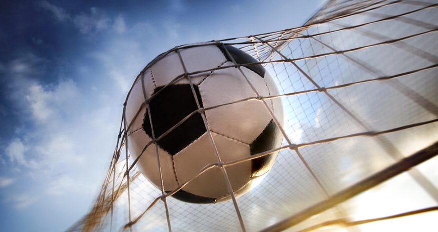 A soccer ball in the back of a soccer net