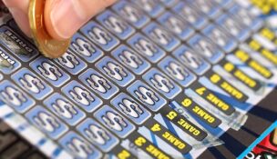 A human hand is scratching a lottery ticket