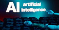 A message reading "AI artificial intelligence", a keyboard, and robot hands are seen in this illustration
